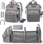 Grey Inclusive LittleOnes diaper bag backpack with a changing station unfolded, showing baby essentials and a pacifier case.