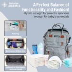 Grey Inclusive LittleOnes diaper bag backpack with a changing station unfolded, showing baby essentials and a pacifier case.