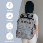 Grey Inclusive LittleOnes diaper bag backpack with a changing station unfolded, showing baby essentials and a pacifier case.