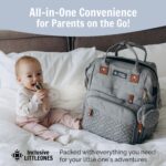 Grey Inclusive LittleOnes diaper bag backpack with a changing station unfolded, showing baby essentials and a pacifier case.