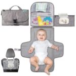 Kopi Baby portable diaper changing pad in classic grey, folded with strap, showing wipes pocket and storage.