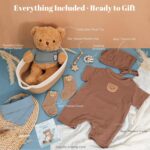 A 9-piece baby boy gift set including a teddy bear outfit, plush bear, pacifier clip, blue bib, and cotton basket.
