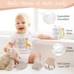 A 9-piece khaki new mom and dad gift set with mugs, baby onesie, swaddle blanket, socks, and affirmation cards.