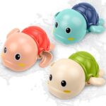 Three colorful TOHIBEE wind-up turtle bath toys, blue, green, and red, floating in water, designed for toddlers.