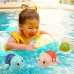 Three colorful TOHIBEE wind-up turtle bath toys, blue, green, and red, floating in water, designed for toddlers.