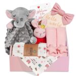 Pink baby girl gift set with swaddle blanket, bunny rattle, elephant lovey, headband, socks, bib, and birth sign in a gift bo