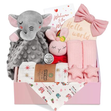 Pink baby girl gift set with swaddle blanket, bunny rattle, elephant lovey, headband, socks, bib, and birth sign in a gift bo