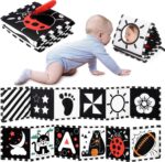 A black and white high contrast baby soft book with a mirror, featuring various patterns like stars and floral designs.
