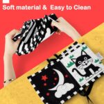 A black and white high contrast baby soft book with a mirror, featuring various patterns like stars and floral designs.